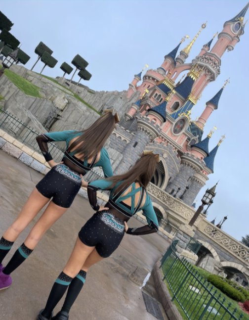 Two Tycoons athletes in uniform in front of the Disney castle