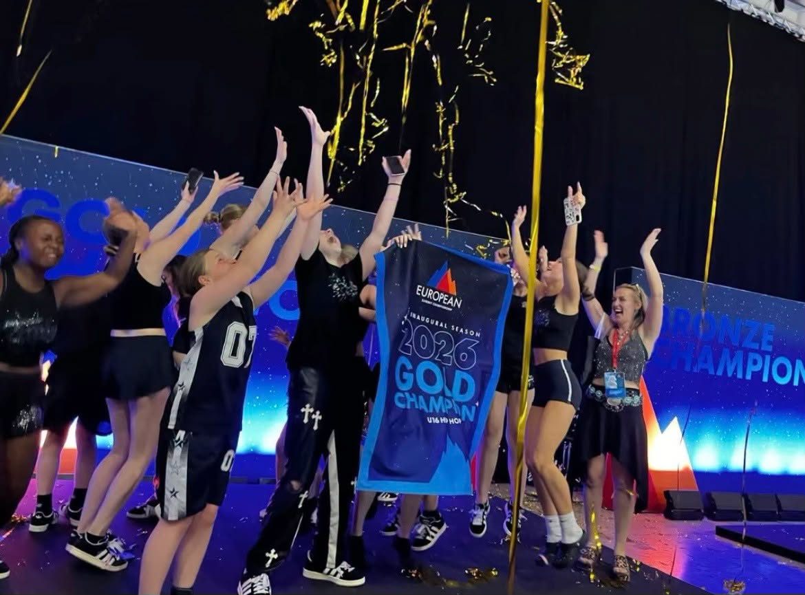 Tycoons hip hop team celebrating on stage with their European Summit gold champion banner