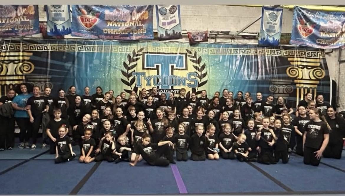 Over 70 Tycoons athletes and coaches together in the gym in matching black Tycoons T-shirts